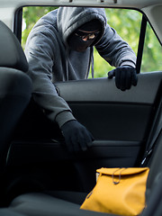 Image showing Transportation crime concept .Thief stealing bag from the car