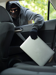 Image showing Car theft - a laptop being stolen through the window of an unoccupied car.