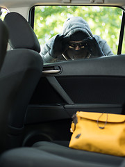 Image showing Transportation crime concept .Thief stealing bag from the car