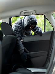 Image showing Car theft - a laptop being stolen through the window of an unoccupied car.