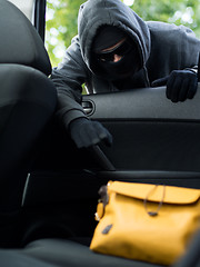 Image showing Transportation crime concept .Thief stealing bag from the car