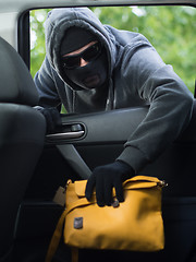 Image showing Transportation crime concept .Thief stealing bag from the car