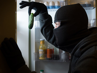 Image showing Thief. Man in black mask with a cucumber.