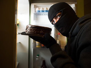 Image showing Thief. Man in black mask with a cake.