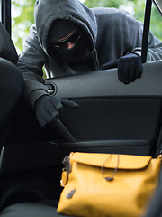 Image showing Transportation crime concept .Thief stealing bag from the car