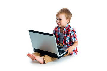 Image showing little blue-eyed boy with a laptop on a white background