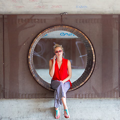 Image showing Young cheerful woman talking on cellphone.