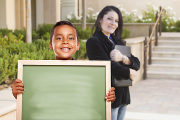 Image showing Boy Holding Blank Chalk Board on Campus with Teacher Behind