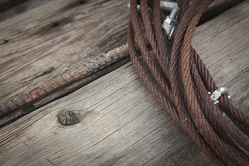 Image showing Abstract Rusty Iron Cable Laying on Old Wood Planks