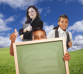 Image showing Young Boys with Blank Chalk Board, Teacher Behind on Grass