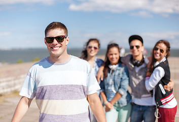 Image showing teenage boy with sunglasses and friends outside