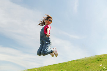 Image showing happy little girl jumping high outdoors