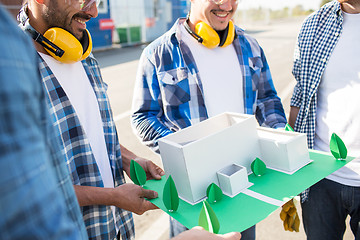 Image showing close up of builders with paper house model