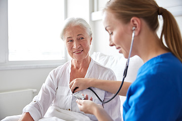 Image showing nurse with stethoscope and senior woman at clinic