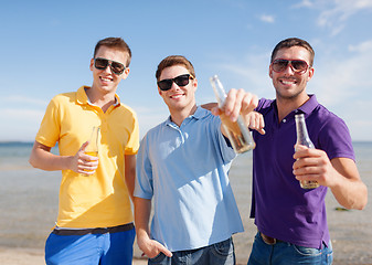 Image showing happy friends with beer bottles on beach