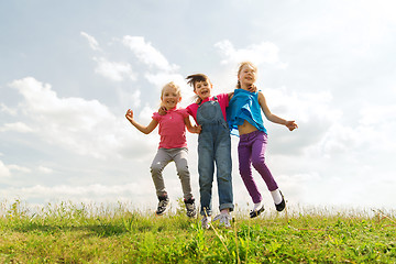 Image showing group of happy kids jumping high on green field