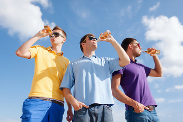 Image showing happy friends with beer bottles on beach