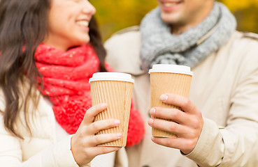 Image showing smiling couple with coffee cups in autumn park