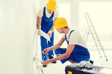 Image showing builders with tablet pc and equipment indoors