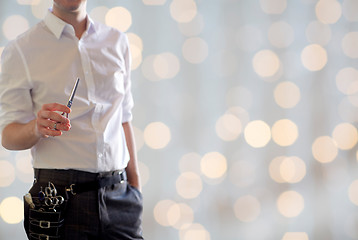 Image showing close up of male stylist with scissors over lights