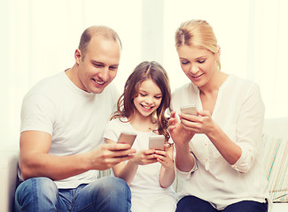 Image showing parents and little girl with smartphones at home