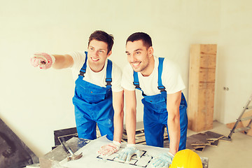 Image showing smiling builders with blueprint