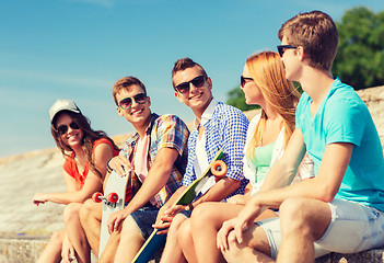 Image showing group of smiling friends sitting on city street