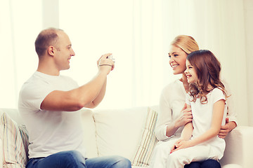 Image showing happy father taking picture of mother and daughter