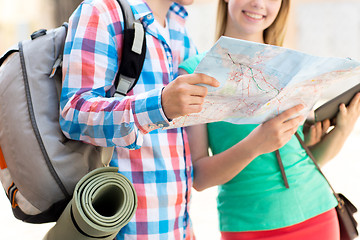 Image showing smiling couple with map and backpack in city