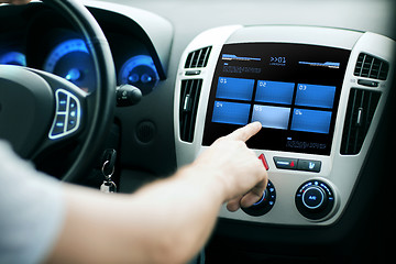 Image showing hand pushing button on car control panel screen