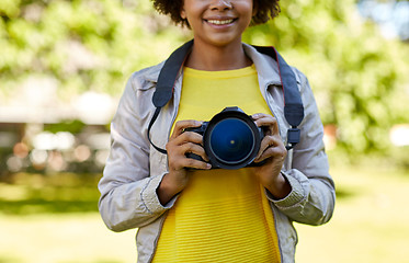 Image showing happy african woman with digital camera in park