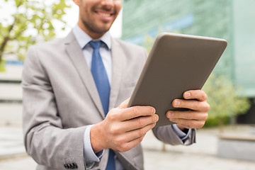 Image showing close up of business man with tablet pc in city