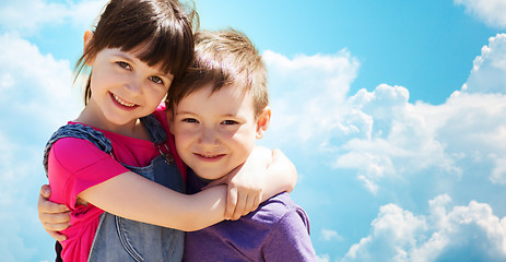 Image showing two happy kids hugging over blue sky and clouds