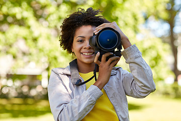 Image showing happy african woman with digital camera in park