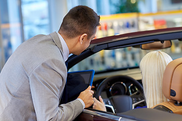 Image showing woman and car dealer with tablet pc in auto salon