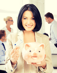 Image showing woman with piggy bank and cash money