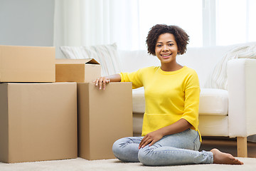 Image showing happy african woman with cardboard boxes at home