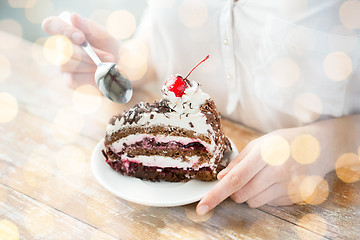 Image showing close up of woman eating chocolate cherry cake