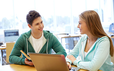 Image showing happy students with laptop and books at library