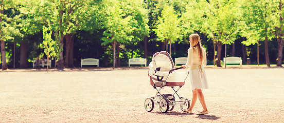 Image showing happy mother with stroller in park