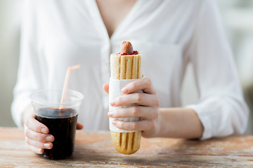 Image showing close up of woman with hot dog and coca cola drink