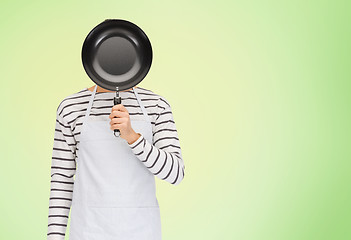 Image showing man or cook in apron hiding face behind frying pan