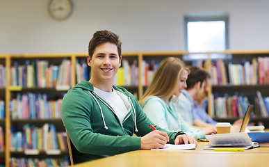 Image showing happy student boy reading books in library