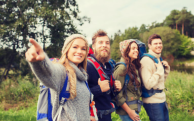 Image showing group of smiling friends with backpacks hiking