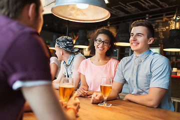 Image showing happy friends drinking beer and talking at bar