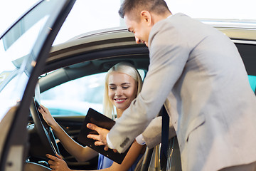 Image showing happy woman with car dealer in auto show or salon