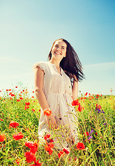 Image showing smiling young woman on poppy field