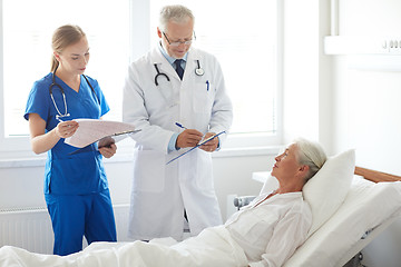 Image showing doctor and nurse visiting senior woman at hospital