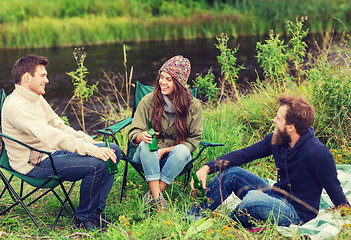 Image showing group of smiling tourists drinking beer in camping