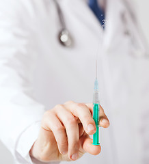 Image showing male hand holding syringe with injection